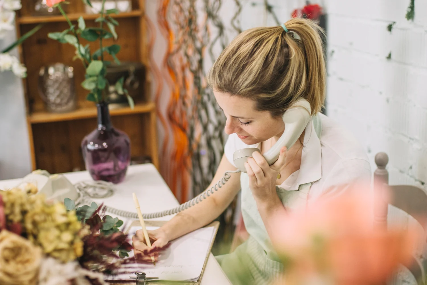 Woman making call whilst making notes