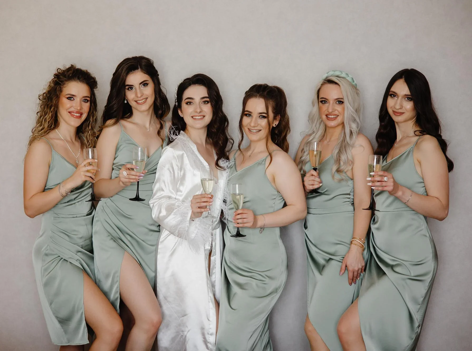 Bride with her bridesmaids in sage green dresses