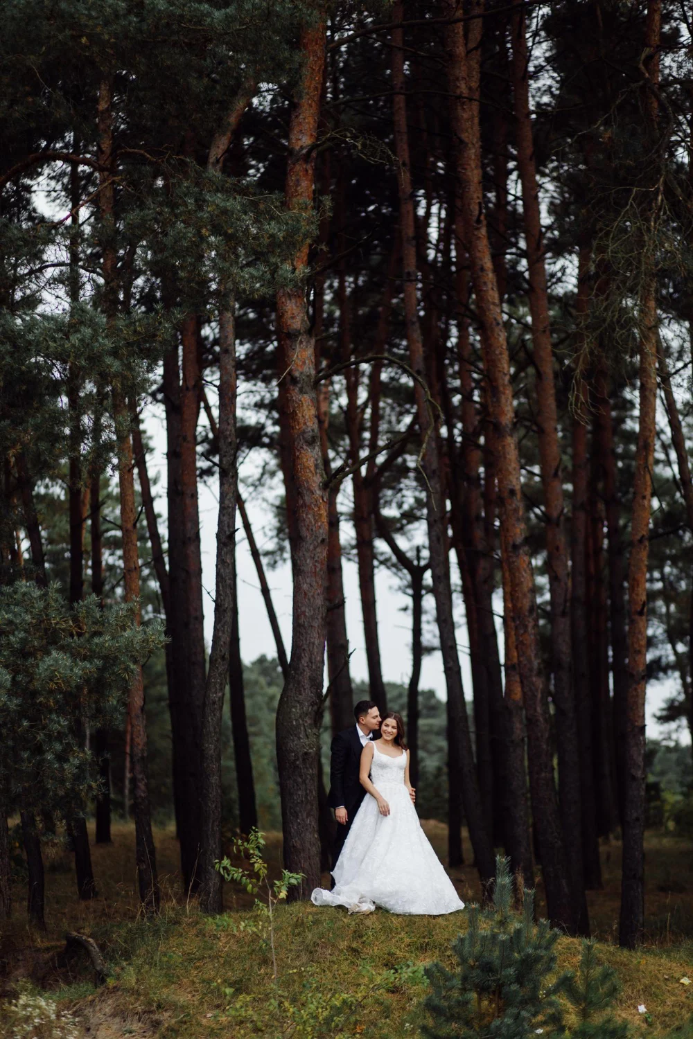 Bride and groom standing in woods