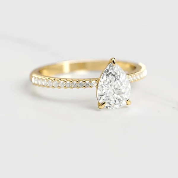 Capucinne Pear Half Pave Tapered Moissanite Ring