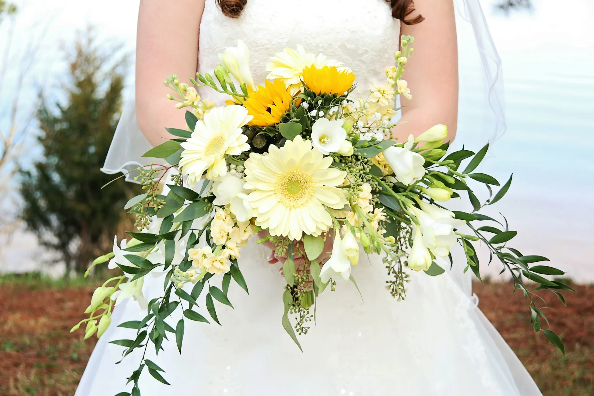 Woman in wedding gown holding bright floral bouquet