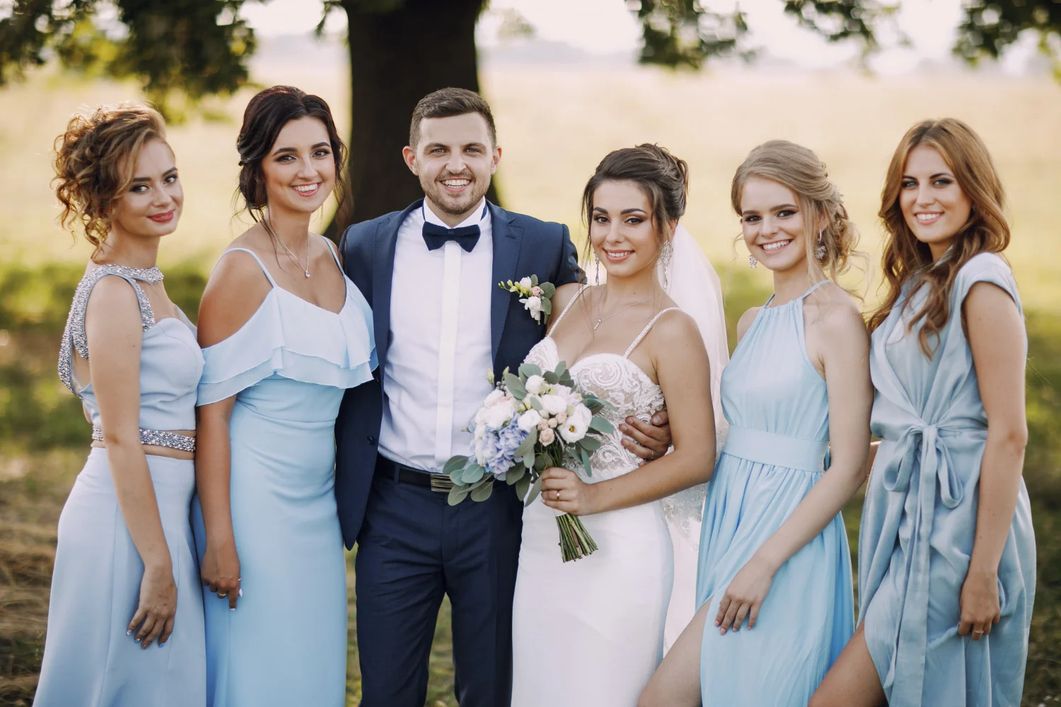 Bride and groom photo with bridesmaids in blue dresses