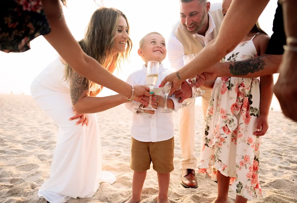 Group of people saying cheers at a beach wedding