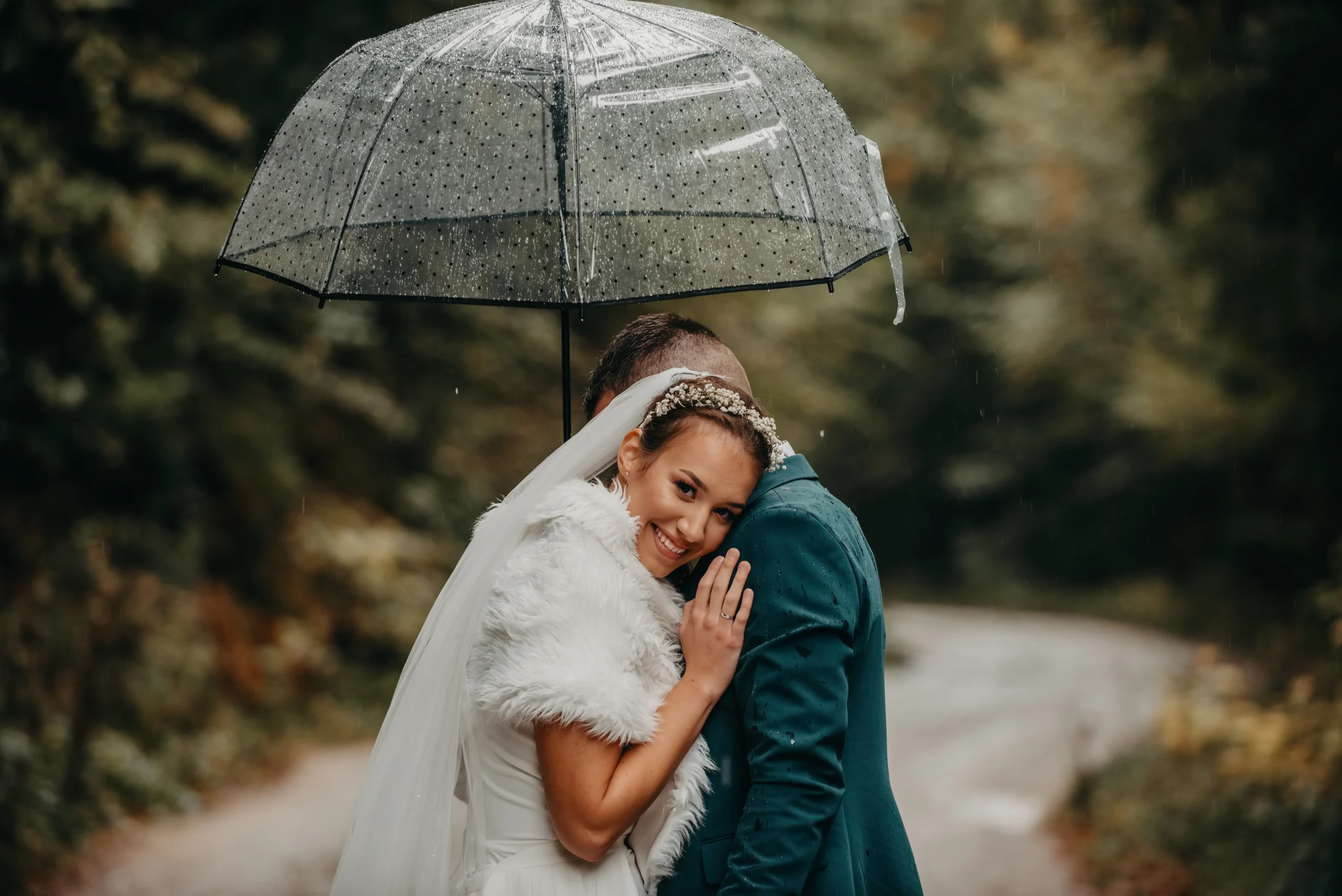 Couple wedding photo under clear umbrella in the rain