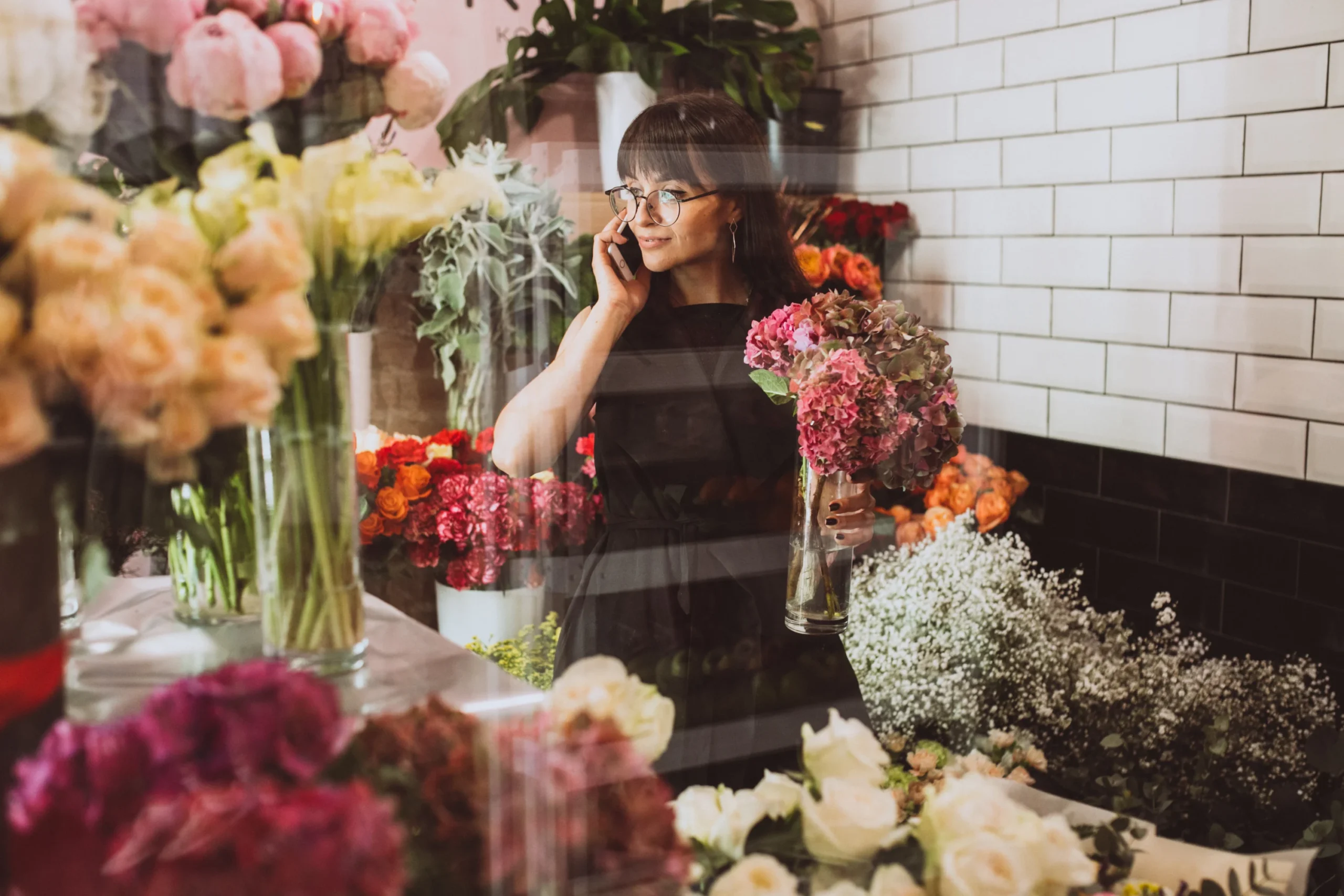 Woman florist in her store on the phone